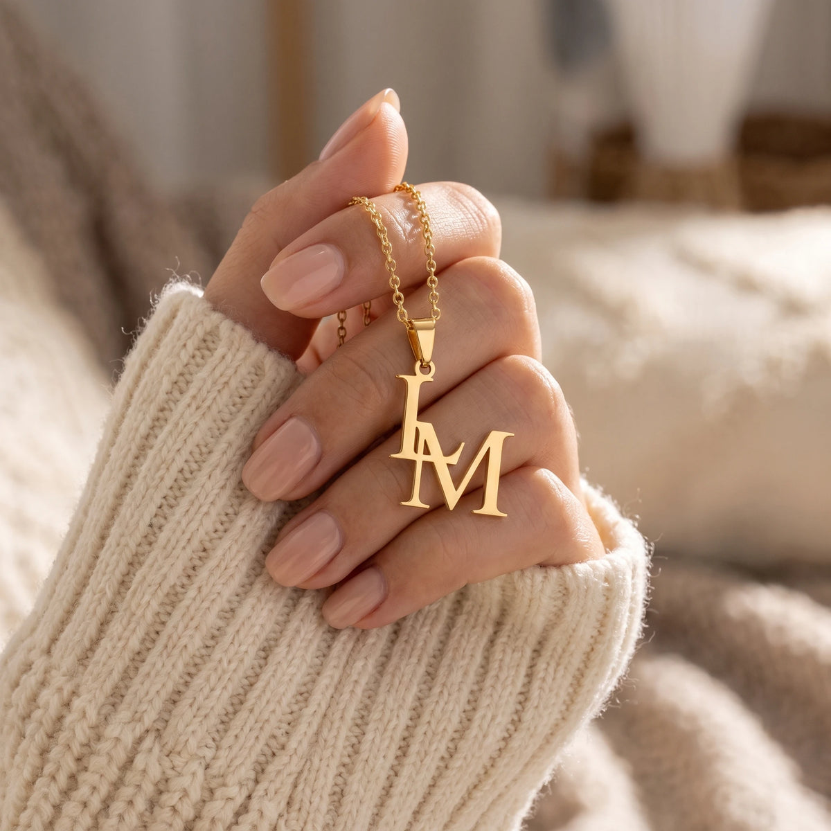 Collier double lettre dans la main, finition dorée
