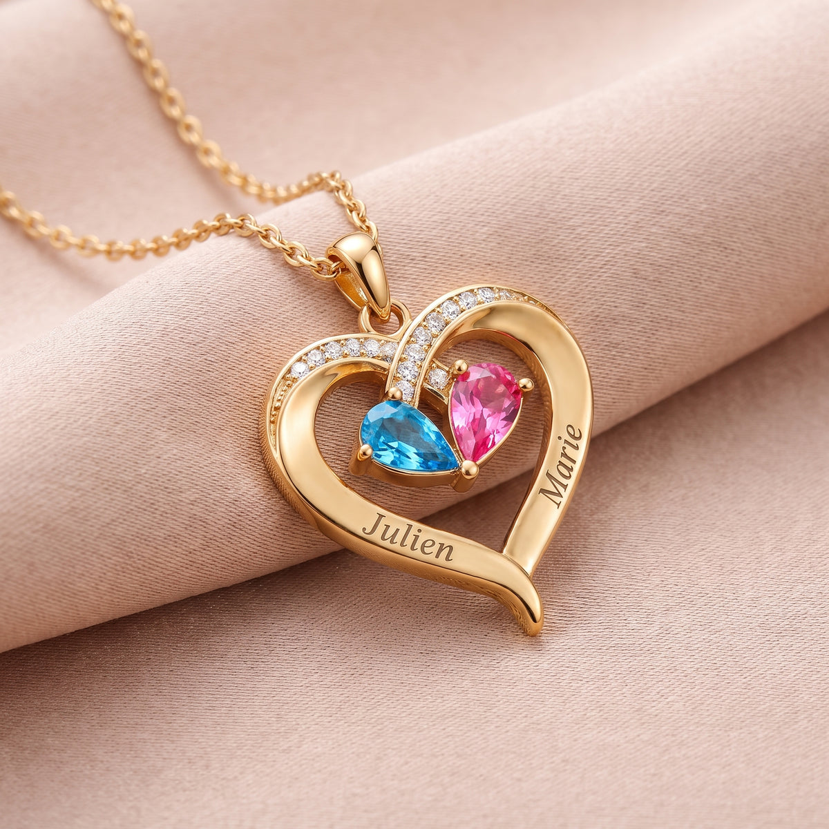 Détail du pendentif cœur doré avec deux prénoms gravés et deux pierres