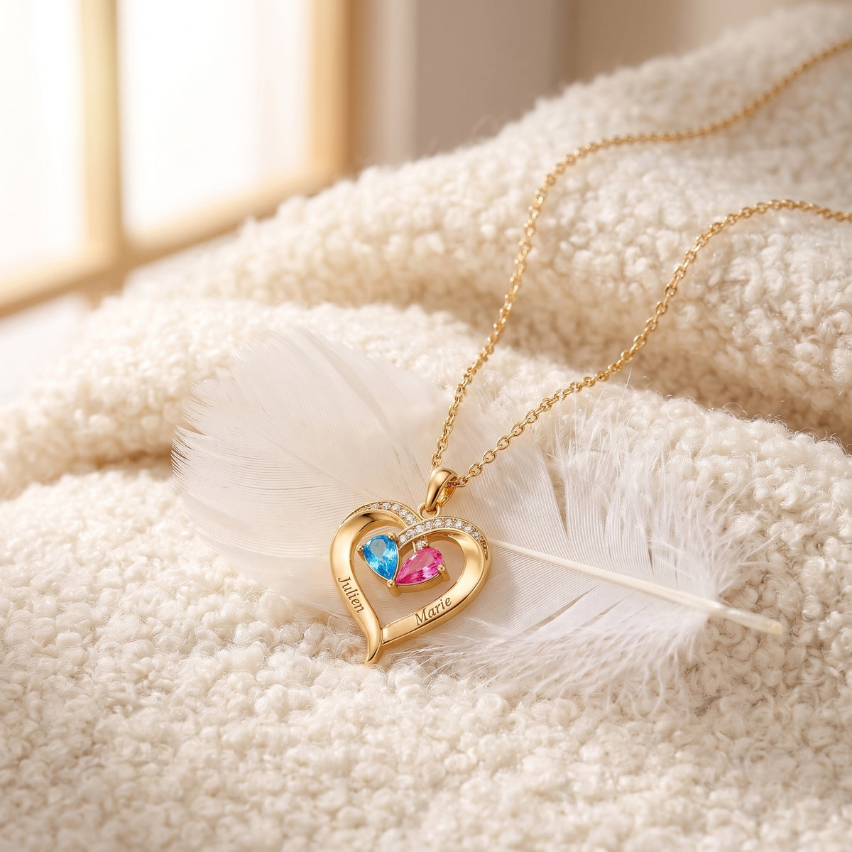 Collier cœur doré sur un plaid avec une plume
