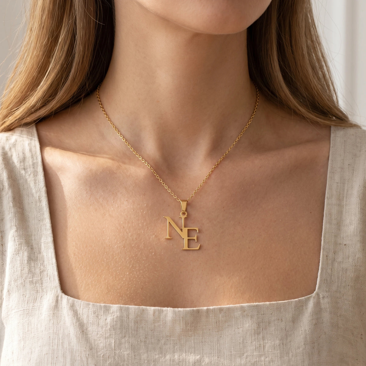 Collier double lettre porté, finition dorée