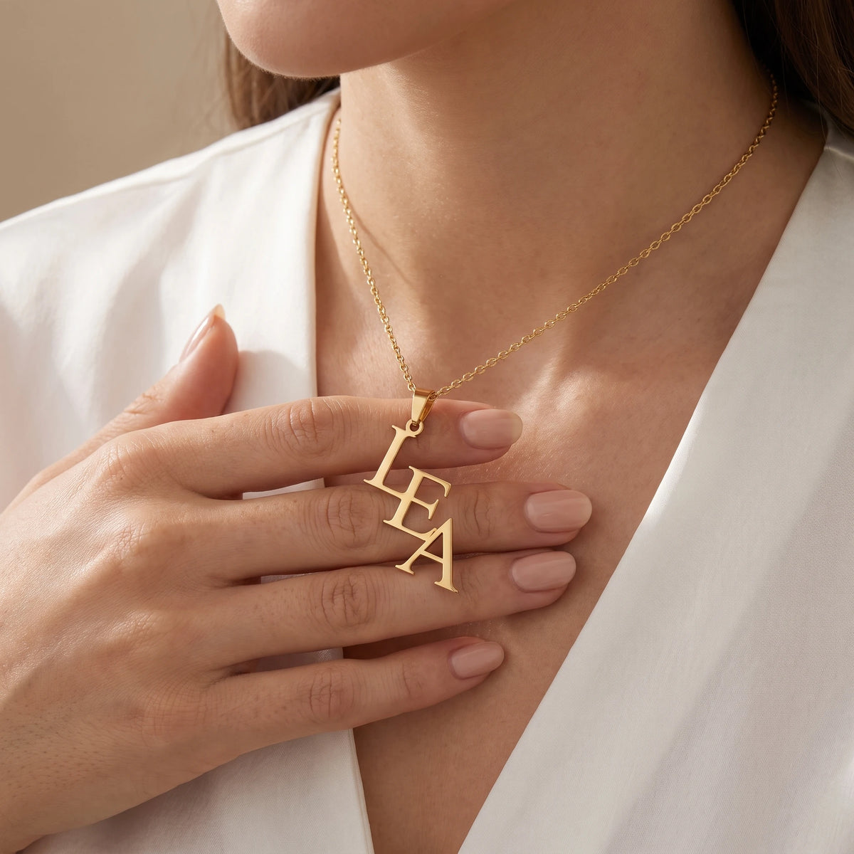 Collier trois lettres porté, finition dorée