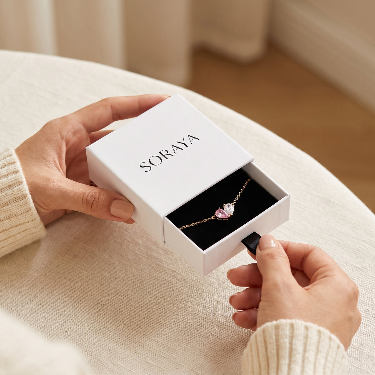 Mains ouvrant l'écrin SORAYA avec le bracelet Liora